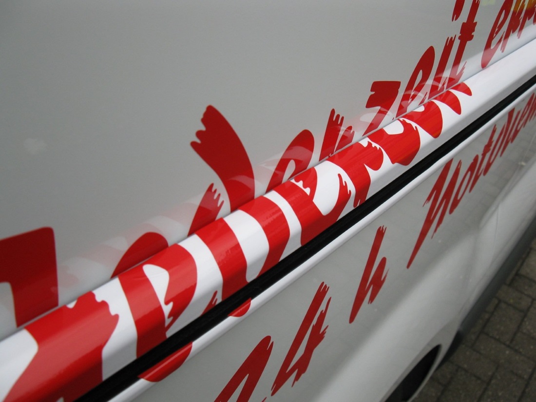 Folienbuchstaben in rot auf ein Fahrzeug geklebt ein weißes Fahrzeug