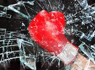roter boxhandschuh zertrümmert eine glasscheibe