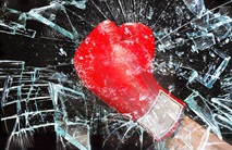 roter boxhandschuh zertrümmert eine glasscheibe